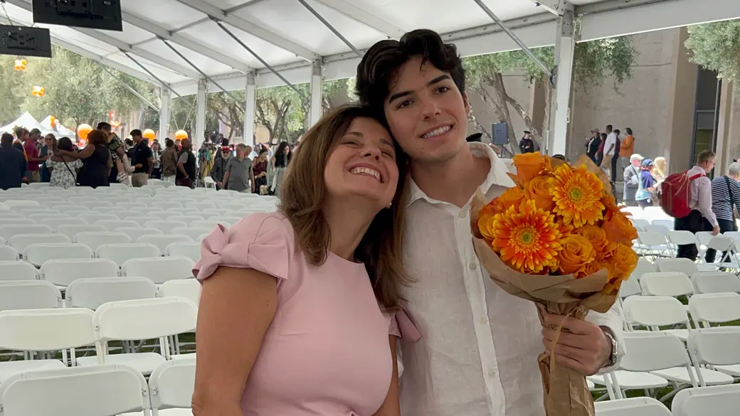 Jonathan with his mom, holding orange flowers
